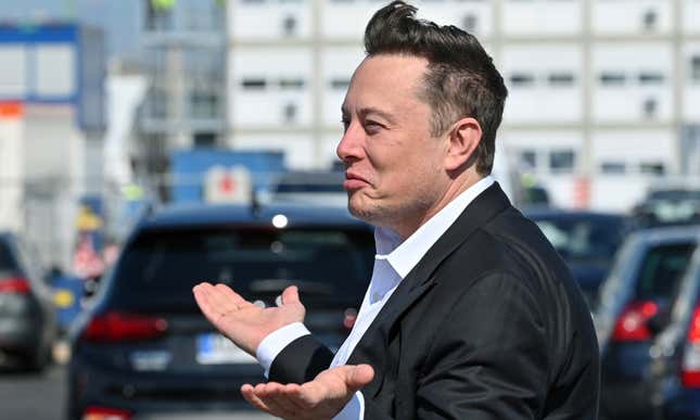 A photo of Elon Musk with his hands in the air. 