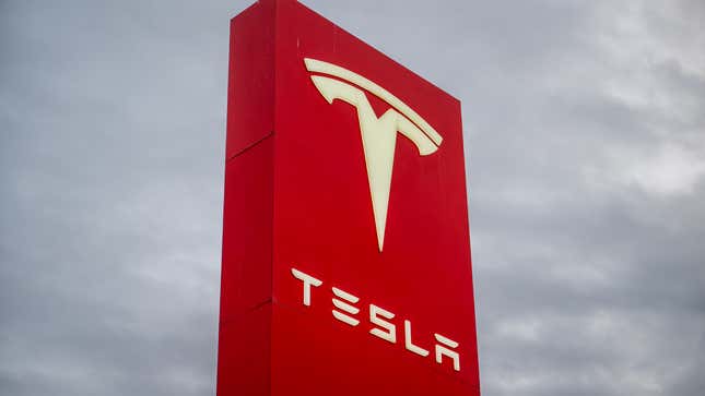 A photo of a Tesla logo at a dealership. 