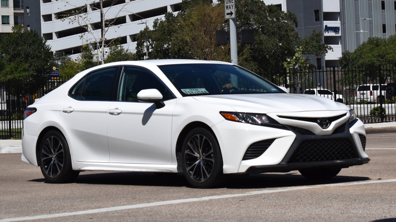 White Toyota Camry driving downtown