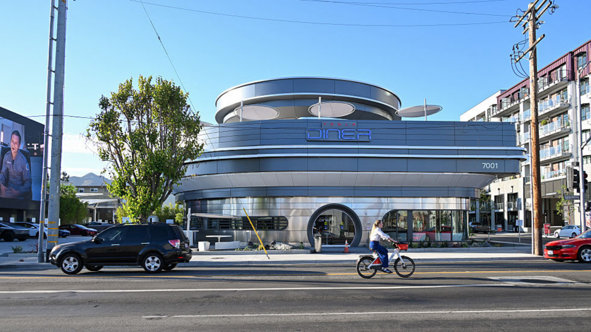 A woman rides a bicycle past Elon Musk's Tesla Diner on Santa Monica Blvd in the Hollywood neighborhood of Los Angeles.