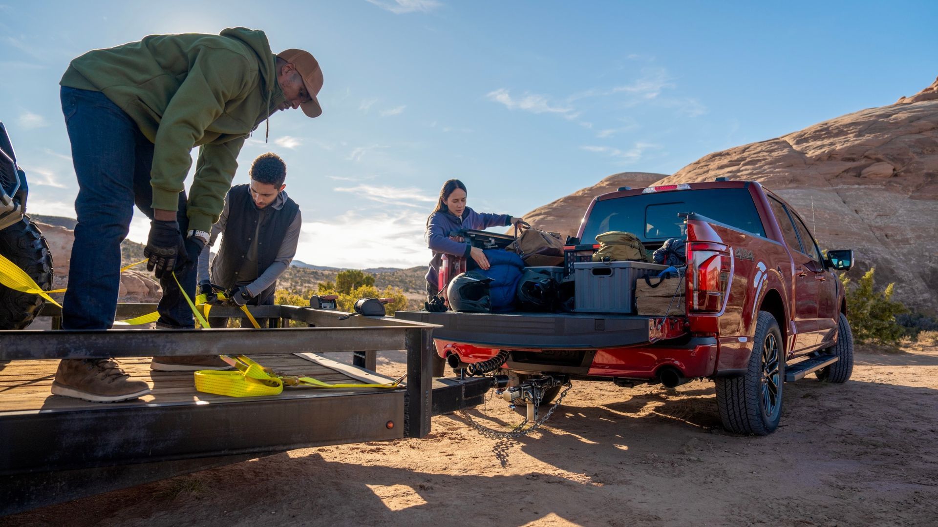 Shot of people loading equipment into the bed of a red 2024 Ford F-150 Lariat.