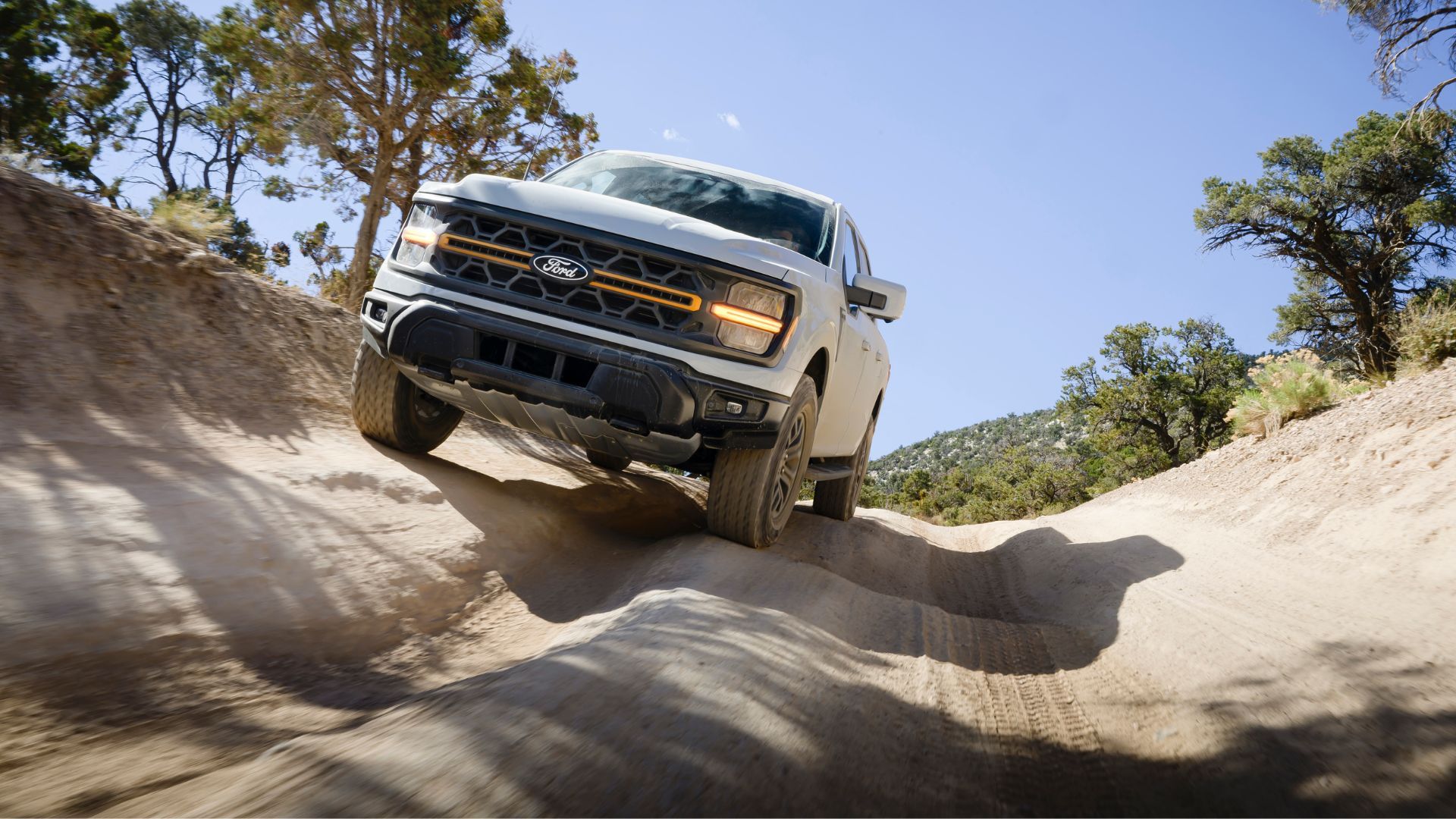 Dynamic front-end shot of a 2024 Ford F-150 Tremor off-roading.