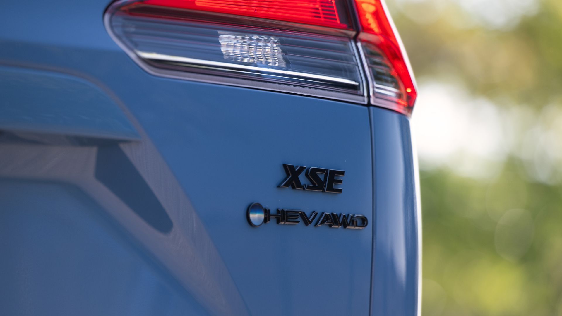 Close-up shot of the badging on the trunk lid of a blue 2026 Toyota Corolla Cross Hybrid XSE AWD.