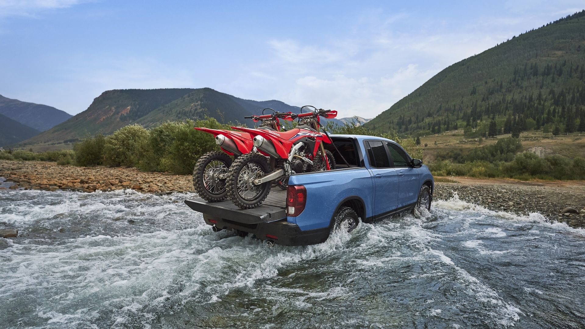 Rear shot of a 2024 Honda Ridgeline TrailSport with dirt bucks in its bed