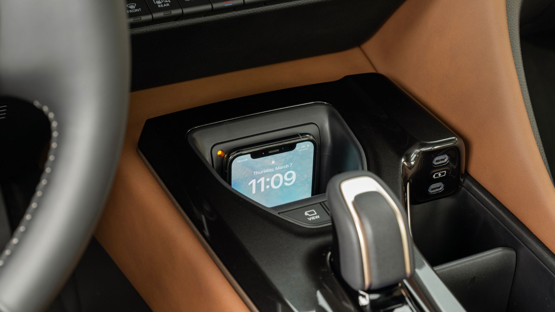 Close-up shot of a smartphone charging via the wireless charger in the 2025 Toyota Crown Signia Limited.