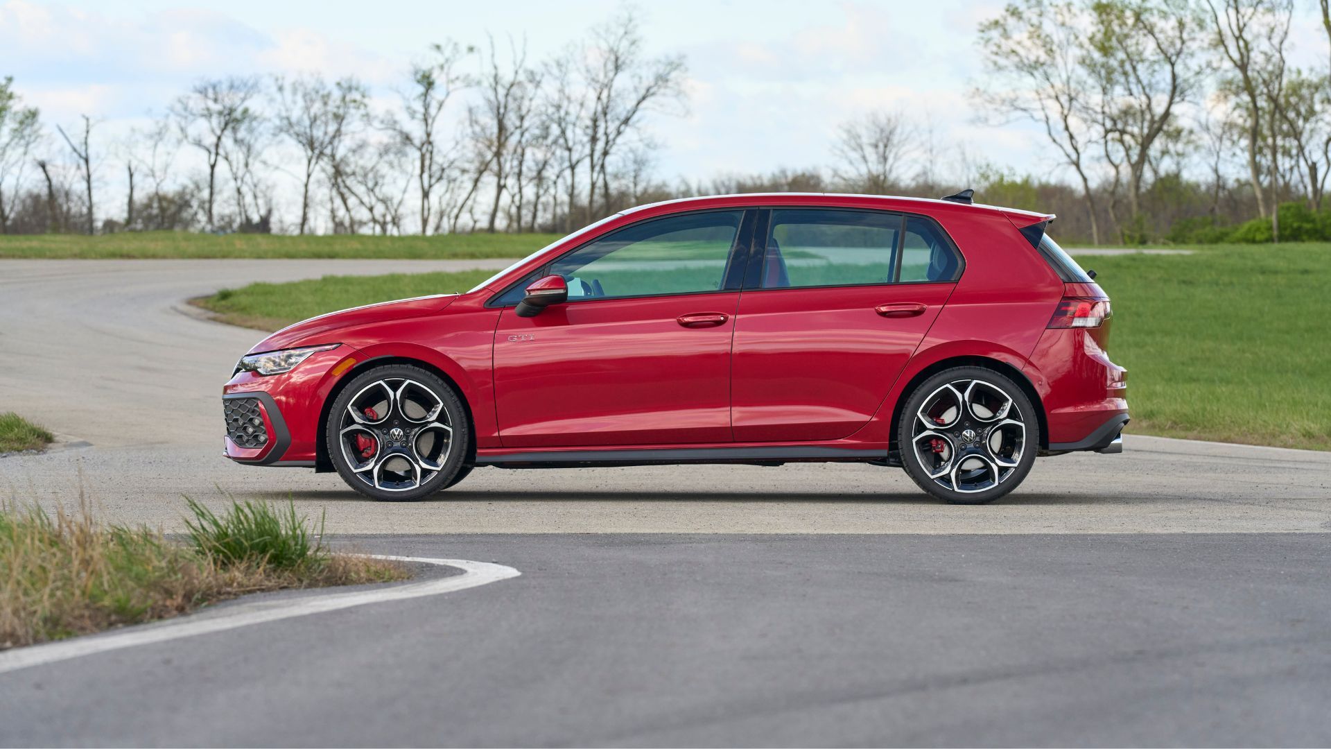 Static side profile shot of a red 2025 Volkswagen Golf GTI Autobahn.